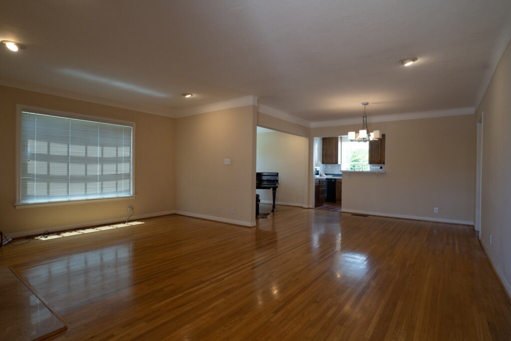 Before: an empty living and dining room with dark tan walls