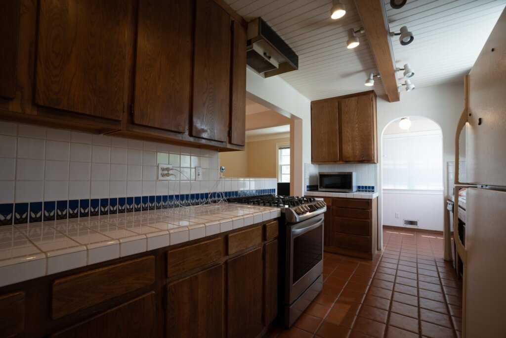 Before: a kitchen with dark wood cabinets and cluttered counters