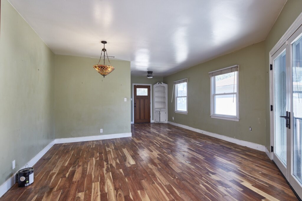 Before: a dining room with dark olive green walls and no furniture